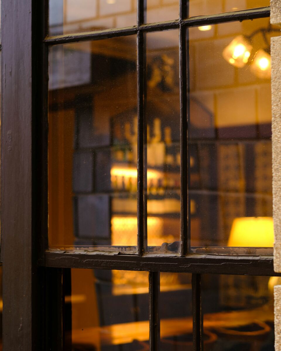 Café le soir, lumière ambrée et lampes allumées.